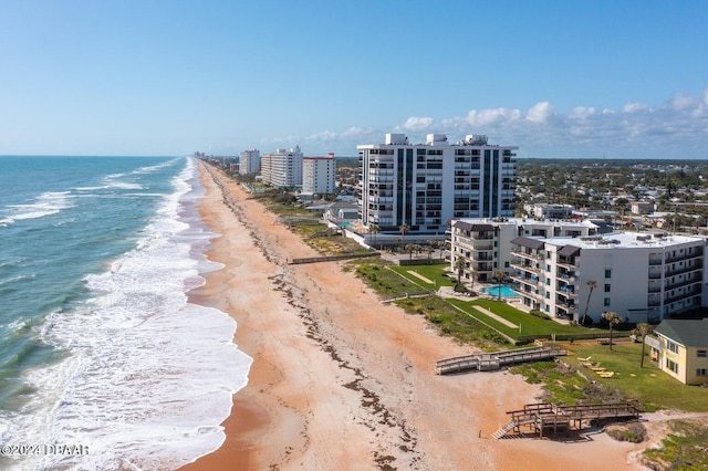 drone / aerial view with a water view and a beach view