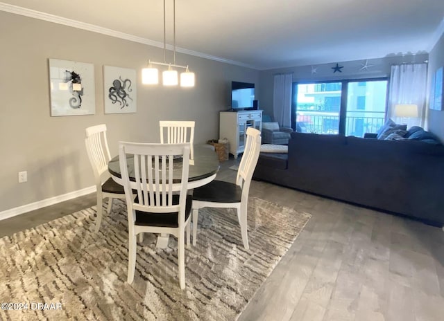 dining space featuring wood-type flooring and crown molding