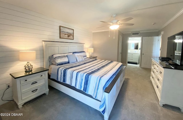 carpeted bedroom featuring wooden walls, ceiling fan, and crown molding