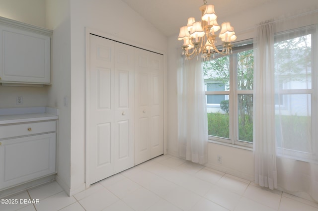 149 Gala Cir, Daytona Beach, FL 32124 - unfurnished dining area featuring a chandelier, lofted ceiling, and light tile patterned floors