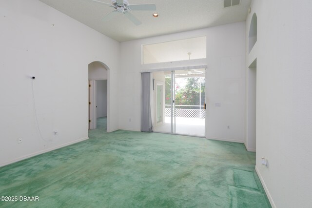 149 Gala Cir, Daytona Beach, FL 32124 - spare room featuring arched walkways, carpet flooring, a ceiling fan, baseboards, and a towering ceiling