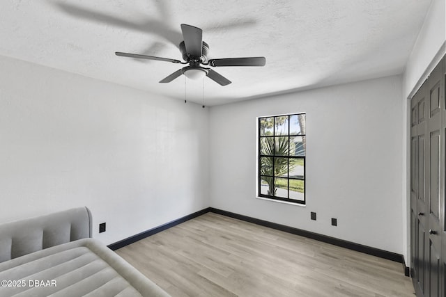 bedroom featuring ceiling fan, light wood-type flooring, a textured ceiling, and a closet