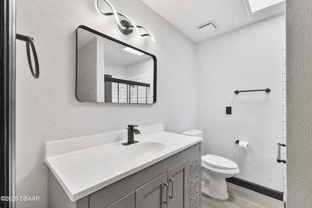 bathroom with vanity, hardwood / wood-style flooring, toilet, and an enclosed shower