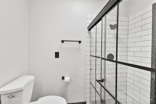 bathroom with toilet and tiled shower