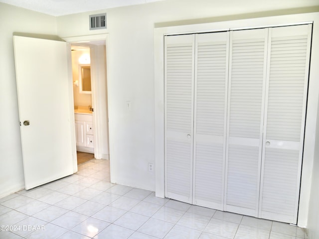 unfurnished bedroom with light tile patterned floors and a closet