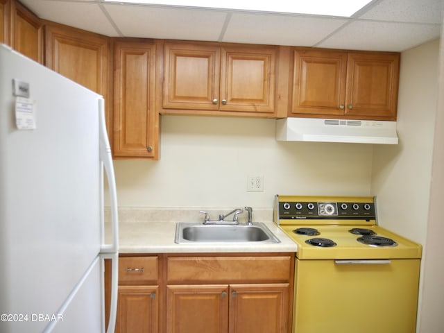 kitchen with white appliances, a paneled ceiling, and sink