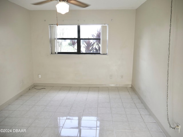 tiled spare room with ceiling fan