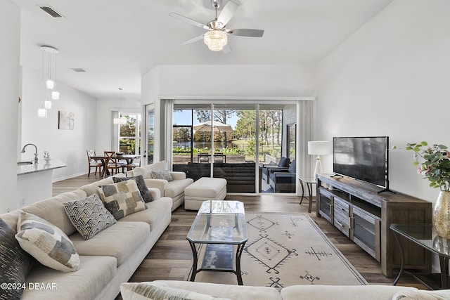 living room with dark hardwood / wood-style flooring, ceiling fan, and sink