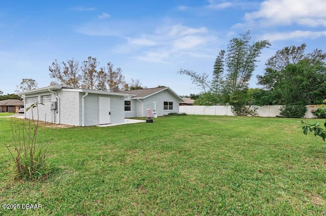 rear view of house featuring a yard and fence