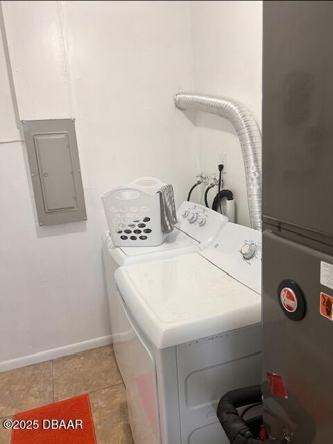 laundry area featuring light tile patterned flooring, laundry area, baseboards, washer and dryer, and electric panel