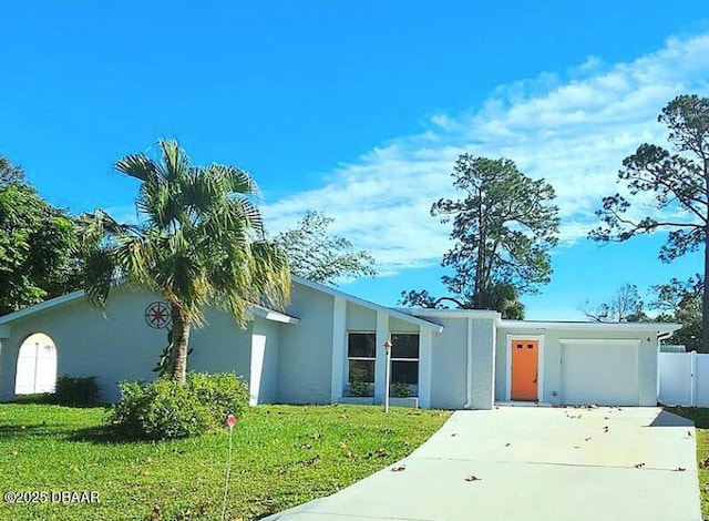 mid-century home featuring stucco siding, an attached garage, fence, driveway, and a front lawn