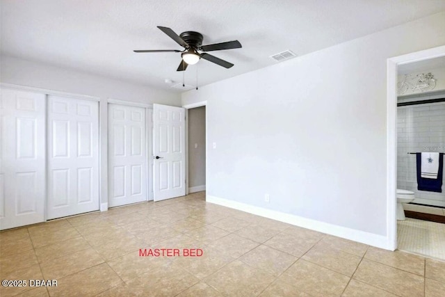 unfurnished bedroom featuring visible vents, a fireplace, baseboards, and two closets