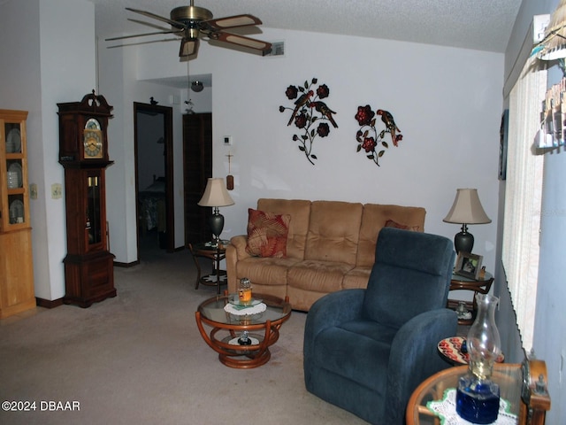 living room featuring carpet flooring, ceiling fan, and a textured ceiling