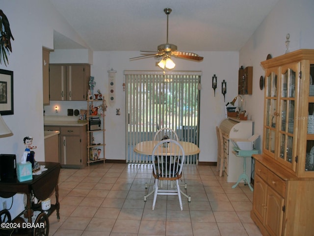 tiled dining space with vaulted ceiling and ceiling fan