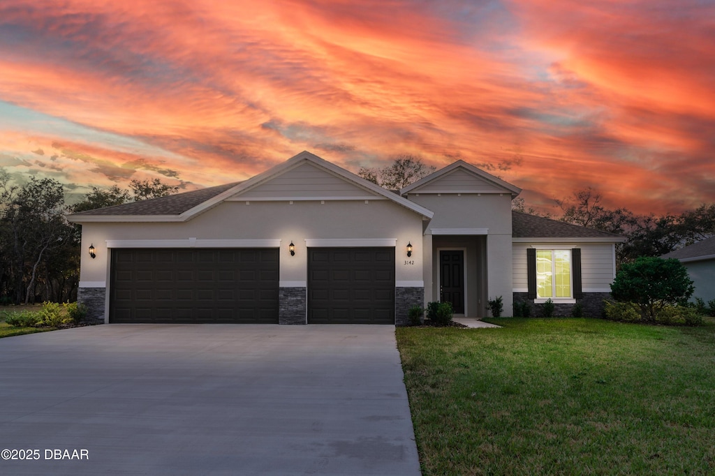 view of front of house with a garage and a yard