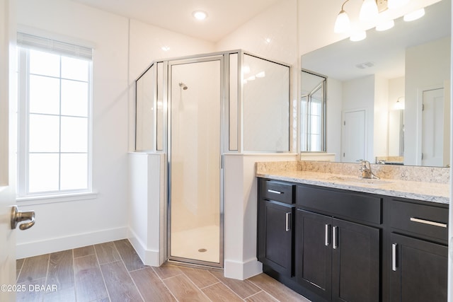 bathroom with vanity, a wealth of natural light, and walk in shower