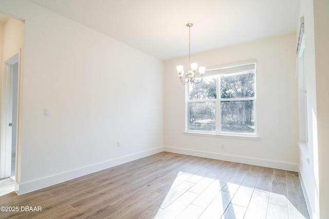 unfurnished room featuring light hardwood / wood-style flooring and a notable chandelier