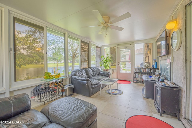 316 Dahoon Holly Dr, Daytona Beach, FL 32117 - sunroom / solarium with a ceiling fan, a water view, tile patterned flooring, and a wood stove