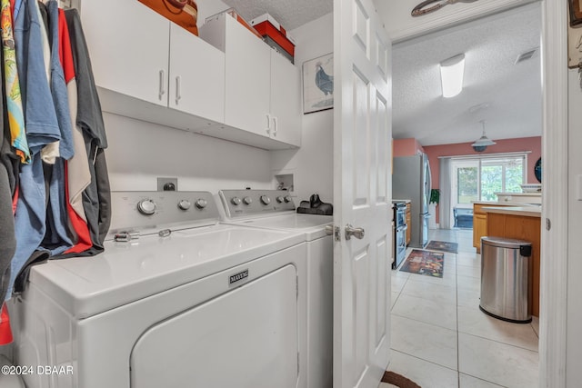 316 Dahoon Holly Dr, Daytona Beach, FL 32117 - laundry area with cabinet space, a textured ceiling, separate washer and dryer, and light tile patterned flooring
