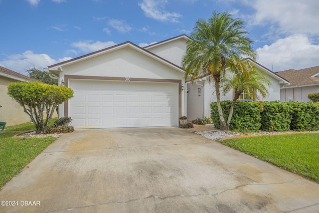 316 Dahoon Holly Dr, Daytona Beach, FL 32117 - ranch-style house featuring stucco siding, driveway, an attached garage, and a front lawn