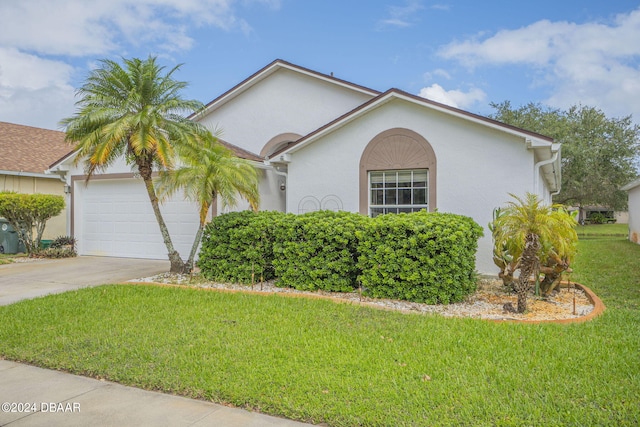 316 Dahoon Holly Dr, Daytona Beach, FL 32117 - view of front of house featuring an attached garage, concrete driveway, a front lawn, and stucco siding