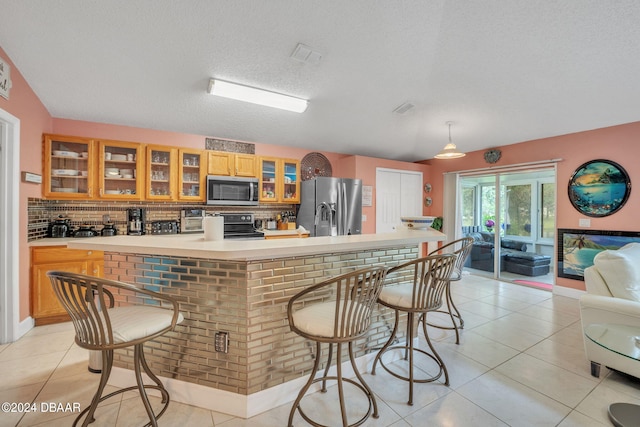 316 Dahoon Holly Dr, Daytona Beach, FL 32117 - kitchen featuring stainless steel appliances, backsplash, light countertops, glass insert cabinets, and a textured ceiling