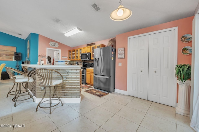 316 Dahoon Holly Dr, Daytona Beach, FL 32117 - kitchen featuring stainless steel appliances, vaulted ceiling, a kitchen breakfast bar, glass insert cabinets, and light tile patterned floors