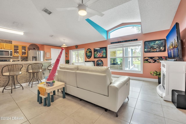 316 Dahoon Holly Dr, Daytona Beach, FL 32117 - living area with vaulted ceiling, a textured ceiling, a ceiling fan, light tile patterned floors, and baseboards