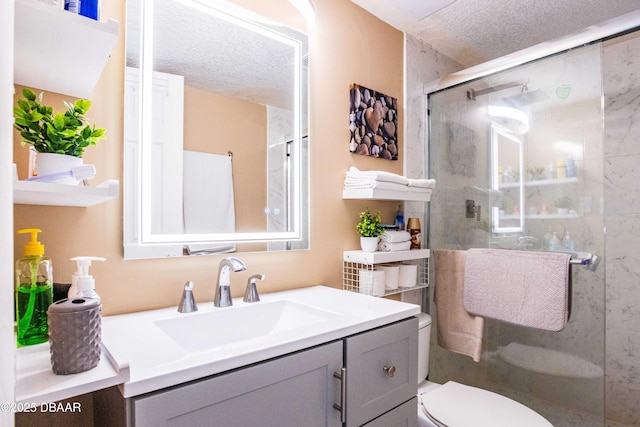 bathroom featuring toilet, a shower stall, vanity, and a textured ceiling