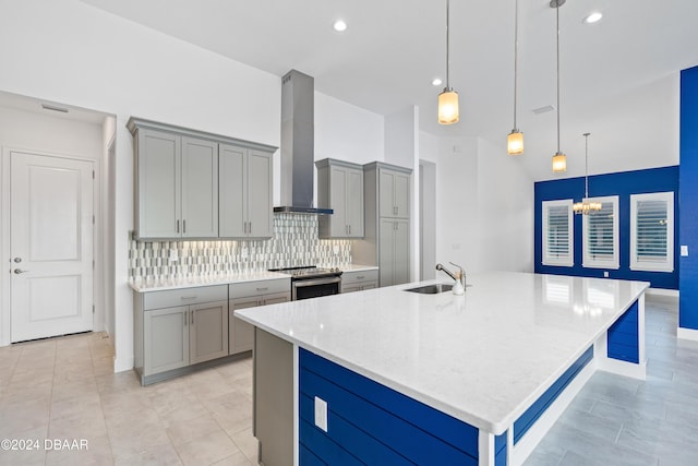 kitchen featuring decorative backsplash, hanging light fixtures, stainless steel electric range, wall chimney exhaust hood, and sink