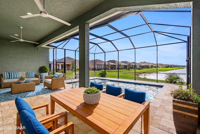 view of patio / terrace featuring glass enclosure, ceiling fan, outdoor lounge area, a water view, and a covered pool