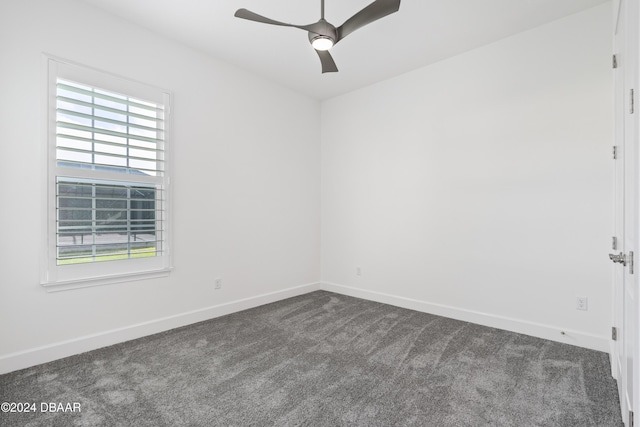 unfurnished room featuring dark colored carpet, ceiling fan, and a healthy amount of sunlight