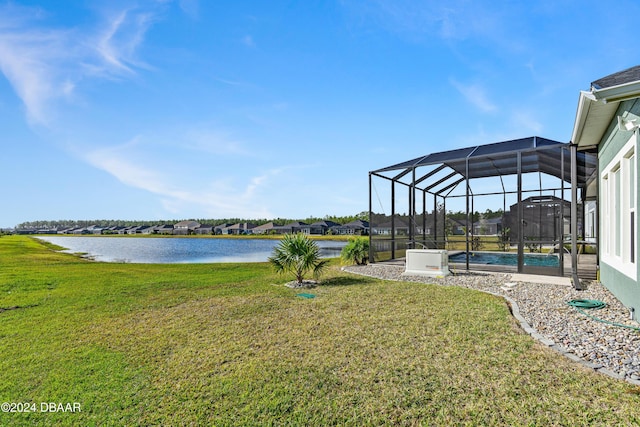 view of yard featuring glass enclosure and a water view