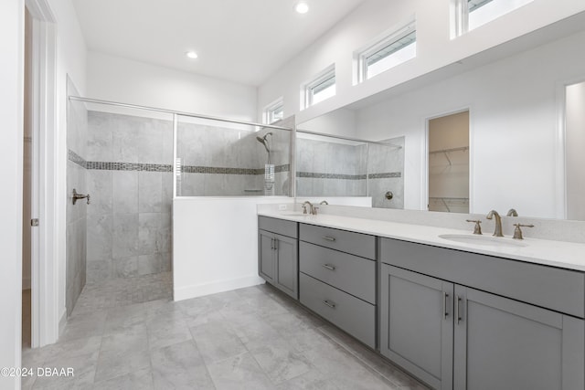 bathroom featuring tiled shower and vanity