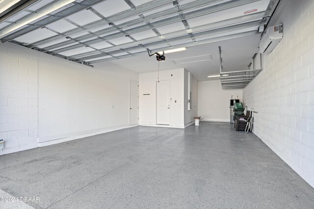 garage featuring a wall mounted AC and a garage door opener