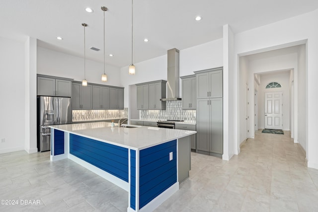 kitchen featuring a spacious island, pendant lighting, decorative backsplash, appliances with stainless steel finishes, and wall chimney exhaust hood