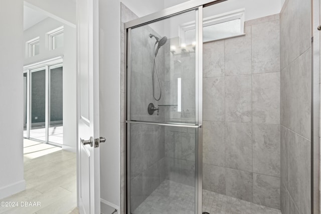 bathroom featuring a shower with door