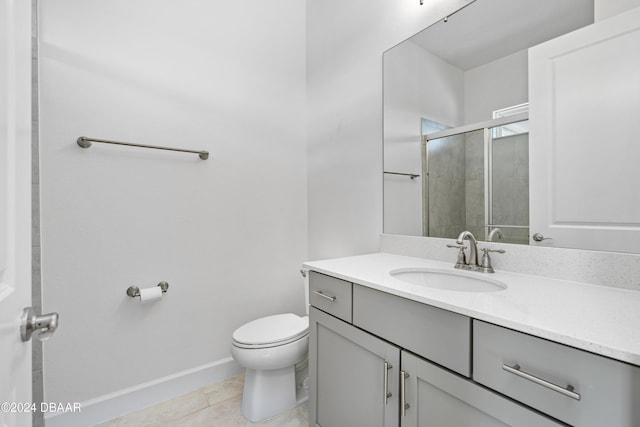 bathroom featuring toilet, tile patterned flooring, a shower with shower door, and vanity