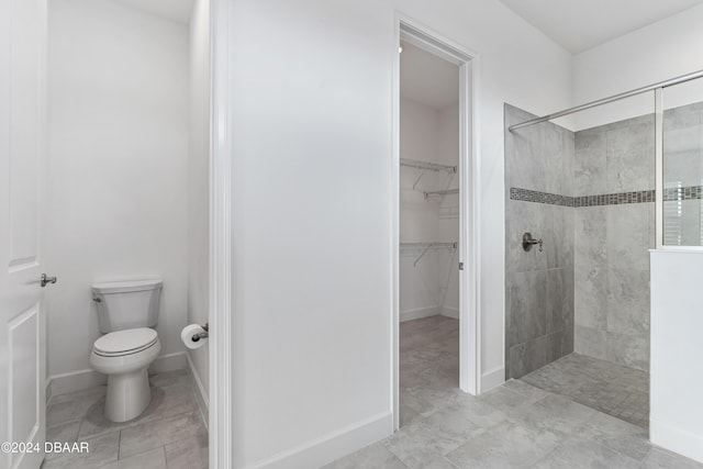 bathroom featuring toilet and tiled shower