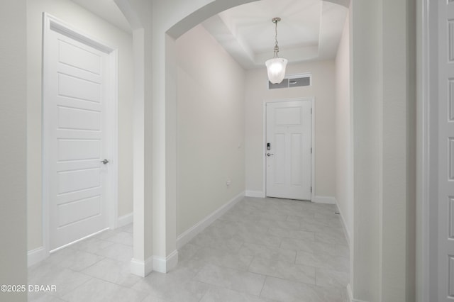 foyer entrance with a tray ceiling