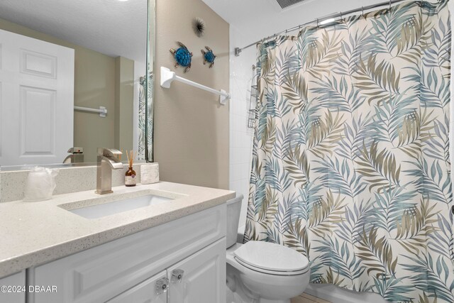 bathroom featuring vanity, curtained shower, and toilet