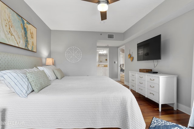 bedroom with dark wood-type flooring, ceiling fan, and connected bathroom