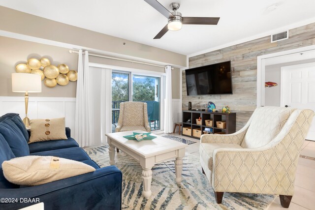 tiled living room with wooden walls and ceiling fan