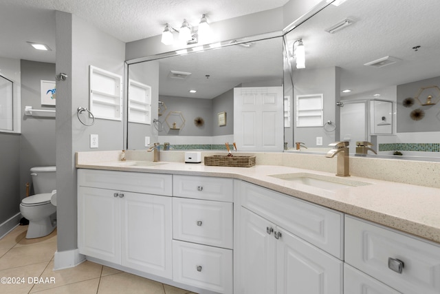 bathroom featuring toilet, tile patterned floors, a textured ceiling, vanity, and a shower with shower door