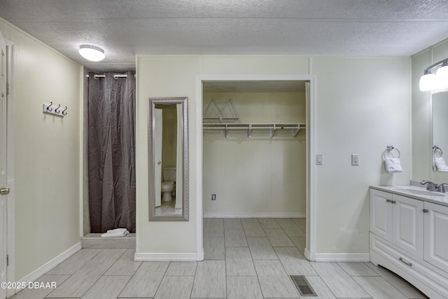 1420 Carol Lee St, Daytona Beach, FL 32117 - full bath featuring vanity, a textured ceiling, curtained shower, wood finish floors, and a walk in closet