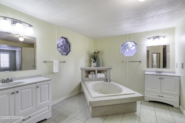 1420 Carol Lee St, Daytona Beach, FL 32117 - bathroom featuring two vanities, a bath, and a textured ceiling