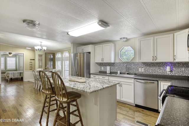 1420 Carol Lee St, Daytona Beach, FL 32117 - kitchen featuring appliances with stainless steel finishes, a sink, plenty of natural light, a textured ceiling, and tasteful backsplash