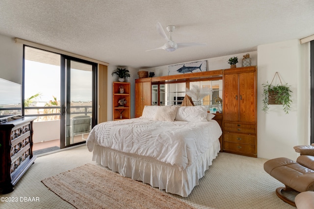 carpeted bedroom with access to outside, floor to ceiling windows, a textured ceiling, and ceiling fan