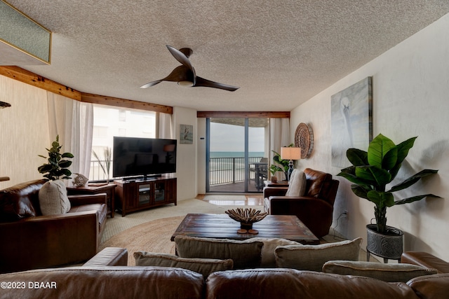 carpeted living room with a textured ceiling and ceiling fan