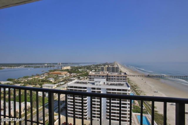 balcony featuring a view of the beach and a water view